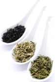 7372934-black-white-and-green-dry-tea-leaves-in-spoons