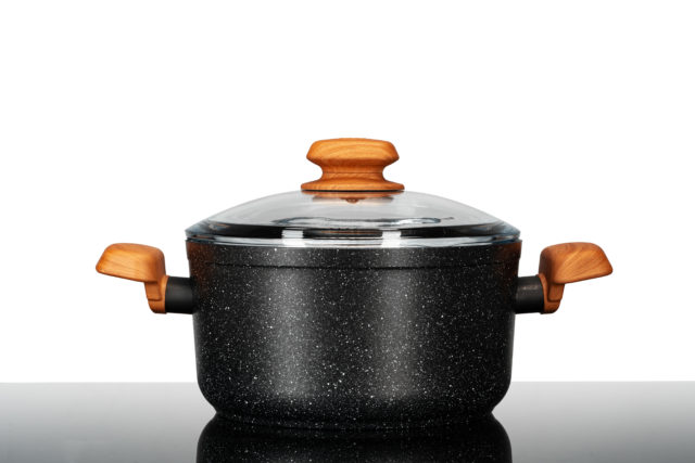 New black cookware with wooden handles close up on kitchen counter