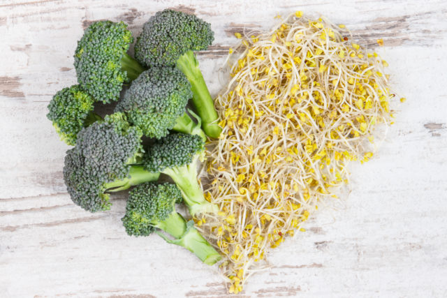 Heart shape made of broccoli sprouts and fresh vegetable. Healthy food containing natural vitamins and minerals