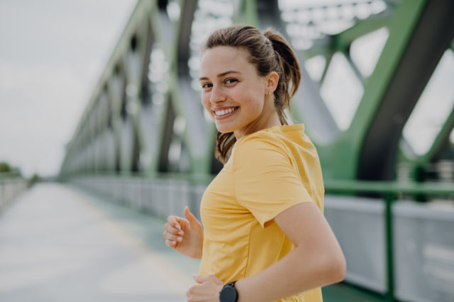 Young woman jogging at a city bridge, healthy lifestyle and sport concept.