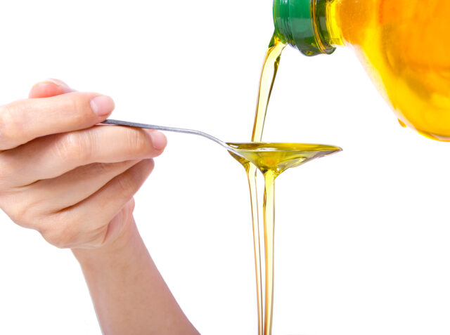 Canola oil being poured into a spoon